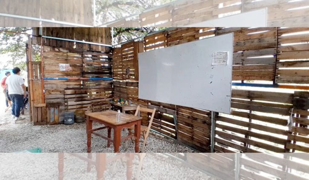 Techos de lámina, paredes construidas con tarimas de madera, suelo de grava, es como se encuentra la escuela.